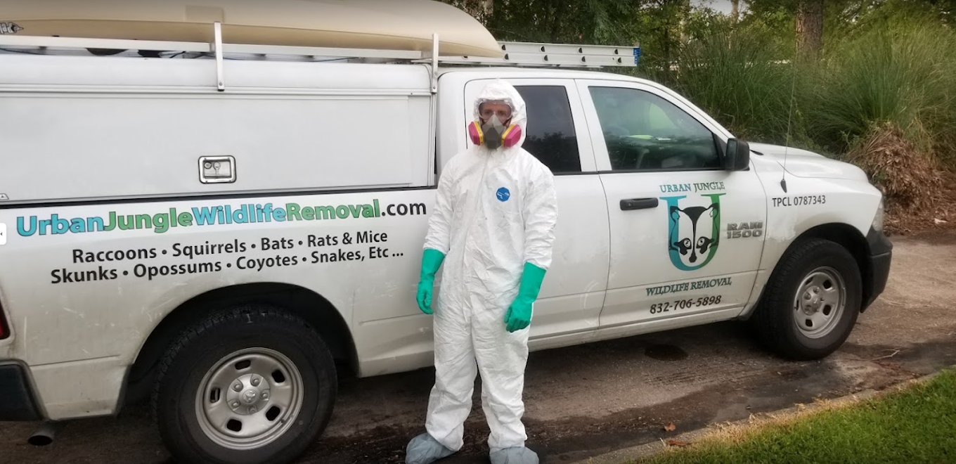 man in wildlife removal suit standing outside of van