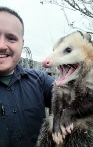 man holding opossum